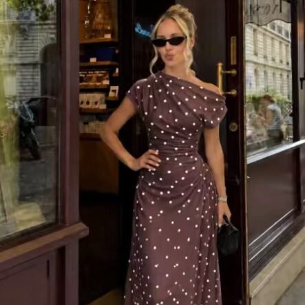 Women's dress with polka dot pattern and boat neckline, with drape